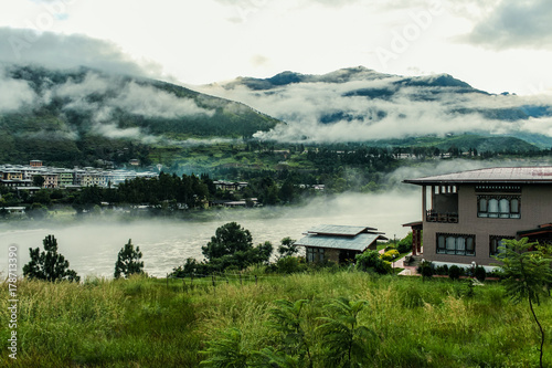 Bhutanese village near the river on a foggy day at Punakha, Bhutan
