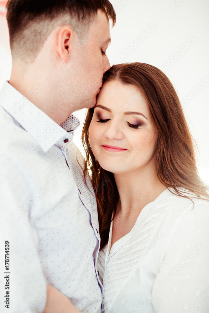 Man embraces woman tender standing in bright room Man embraces woman tender standing in bright room