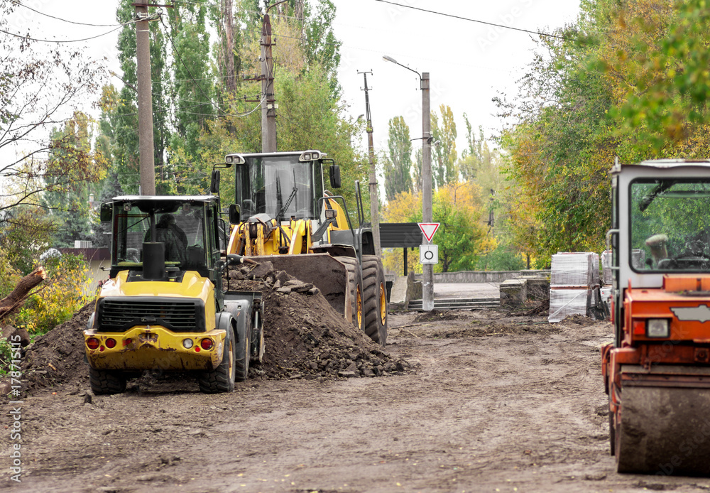 two wheel loader clears the road during construction work