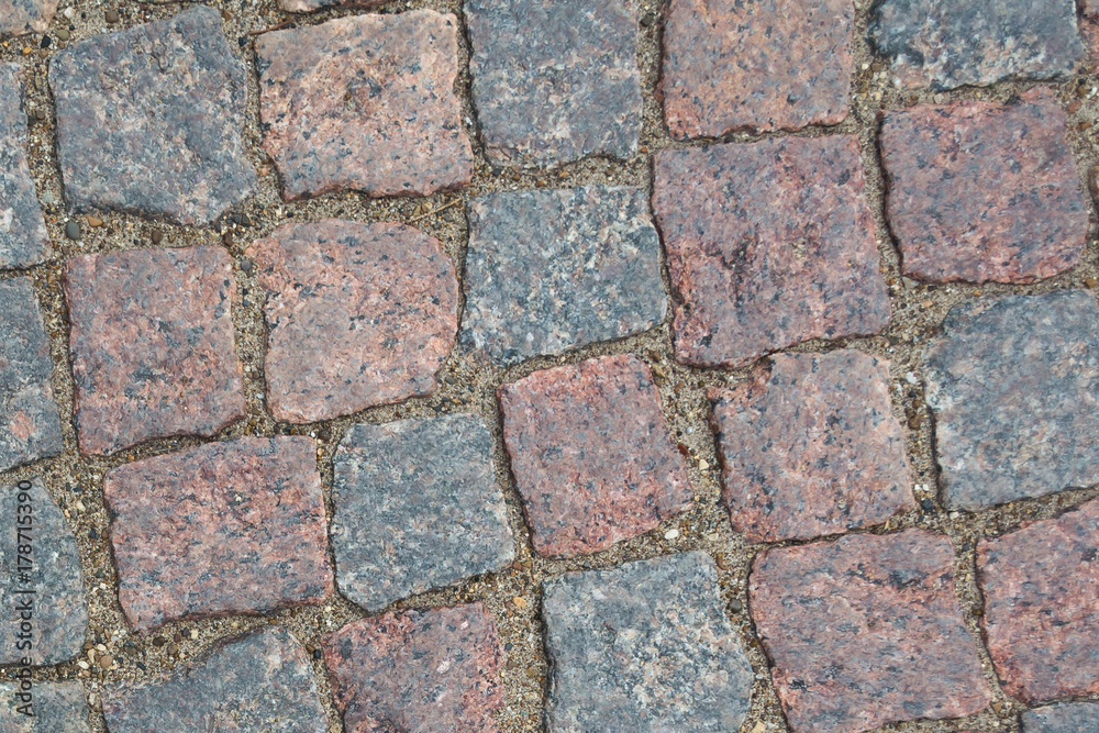 cobblestone pavement. Texture of cobblestone road close-up. Part of the road paved with red black granite. cobblestone pavement. Texture of cobblestone road close-up. Part of the road paved with red black granite.