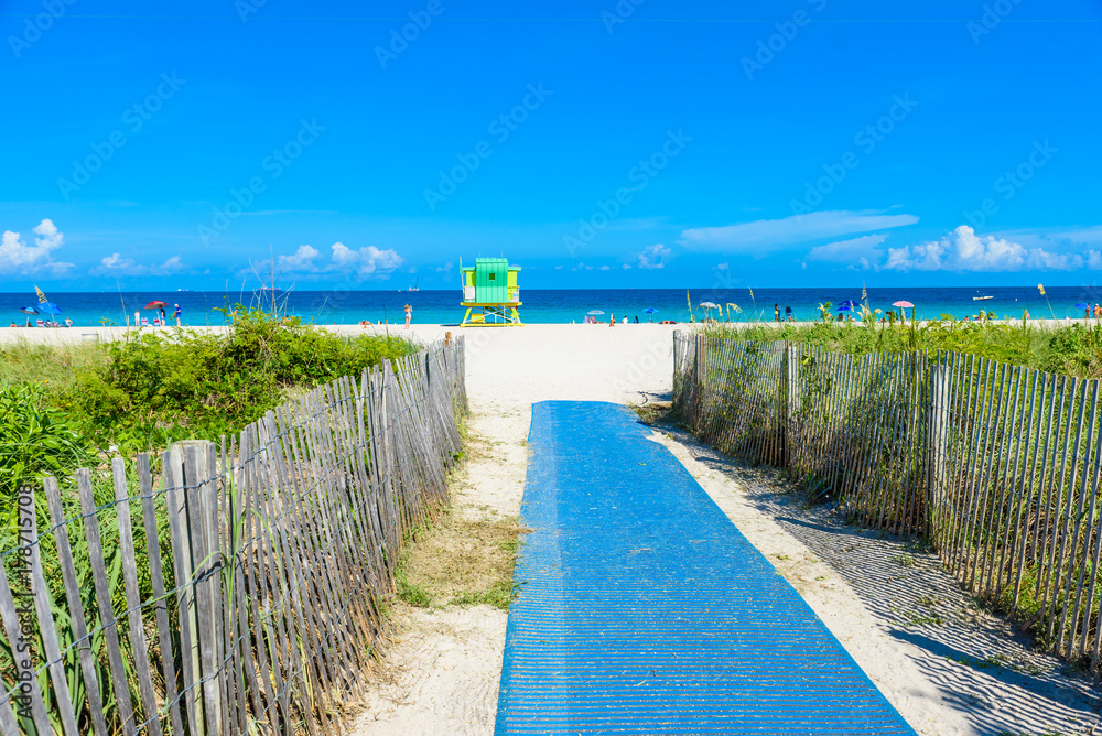 Fototapeta premium Miami South Beach, lifeguard house in a colorful Art Deco style at sunny summer day with the Caribbean sea in background, world famous travel location in Florida, USA