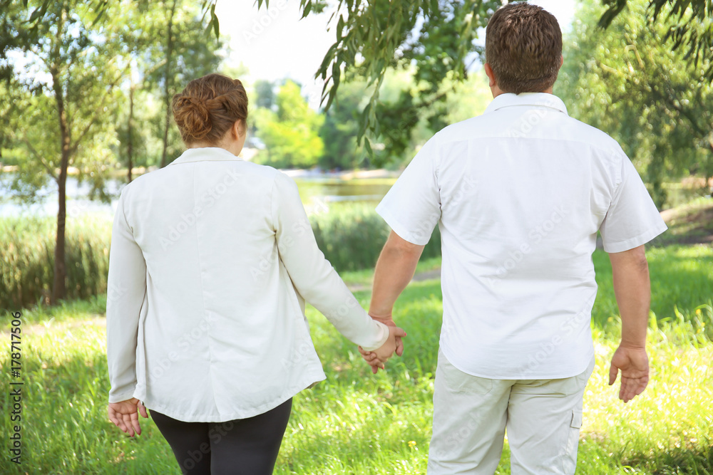 Obraz premium Overweight couple in park on sunny day