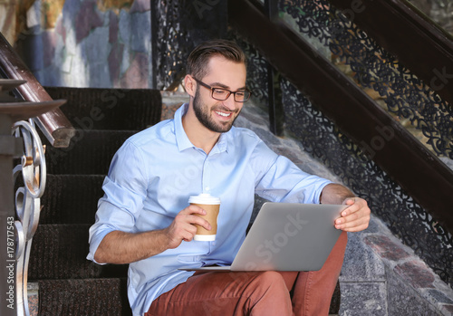 Handsome man with laptop si...