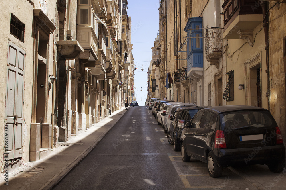 One of the old, historical streets in Valletta / Malta. Image shows architectural style of the city and lifestyle. It's the capital of the Mediterranean island nation of Malta.