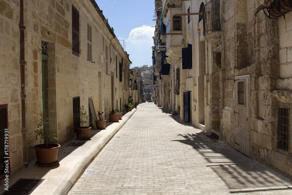 One of the old, historical streets in Valletta / Malta. Image shows architectural style of the city and lifestyle. It's the capital of the Mediterranean island nation of Malta.