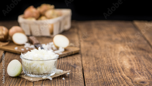 White Onions (dices) on wooden background; selective focus
