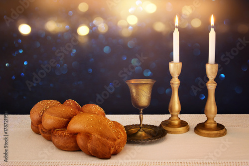 shabbat image. challah bread, shabbat wine and candles on the table photo