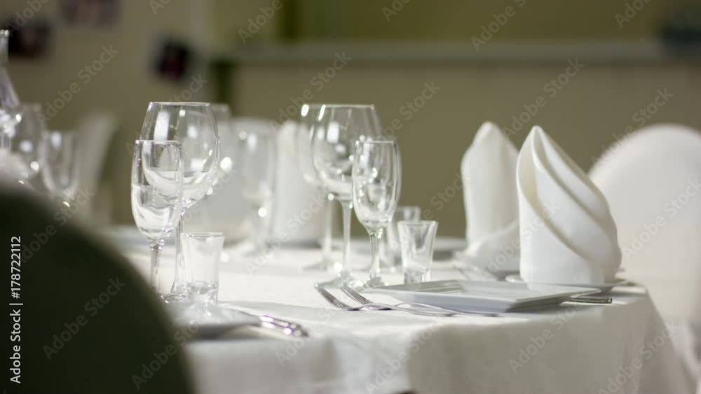 Waiter hand making dinner table looks better before event at luxury restaurant Waiter hand making dinner table looks better before event at luxury restaurant