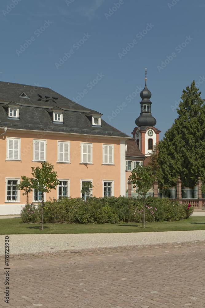 Schwetzingen, Germany - a palace courtyard with a church tower in the background