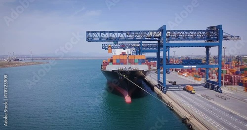 Aerial view of an industrial port where freight loads are carried for national and international shipping by sea or ocean on cargo ships. Concept of: transportation, ships, trade.