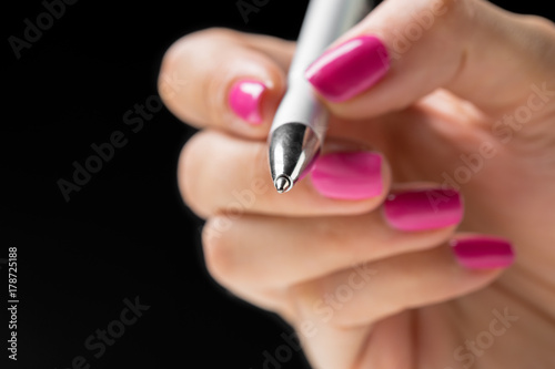 Female hand holding a pen close up