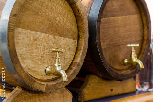 Wooden barrels for wine with a tap of yellow metal.