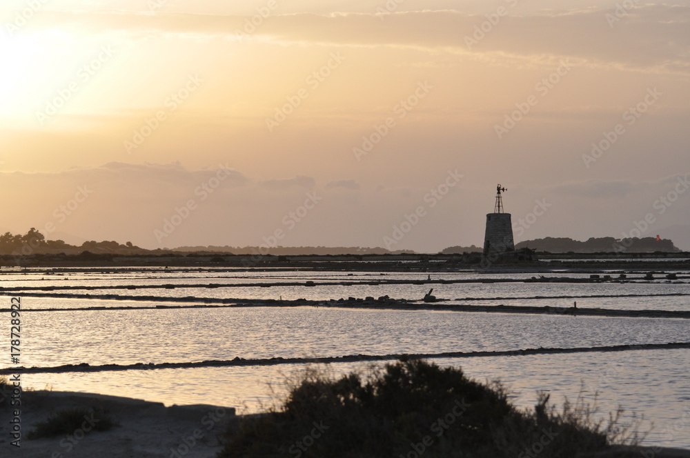 Saline di Marsala con i suoi mulini e vasche al tramonto