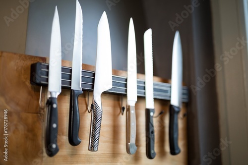 Set of kitchen knives hanging on the wall photo