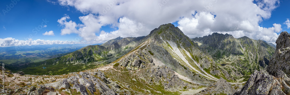 Mountain stone range peak against blue cloudy sky. Nature landscape. Travel background. Holiday, hiking, sport, recreation. National Park High Tatra, Slovakia, Europe