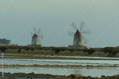 Saline di Marsala con i suoi mulini e vasche al tramonto photo