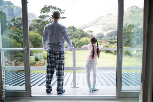 Father and daughter standing together in balcony