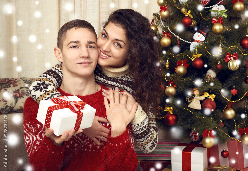 Happy couple in christmas decoration at home. New year eve, ornated fir tree. Winter holiday and love concept. Happy couple in christmas decoration at home. New year eve, ornated fir tree. Winter holiday and love concept.