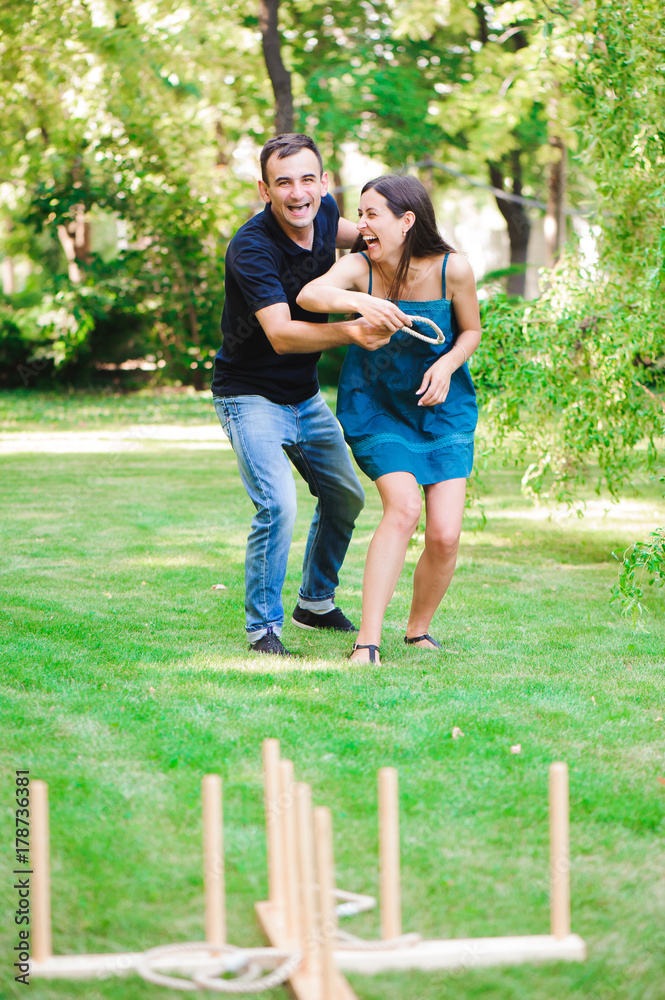Fototapeta premium Friends plaing outdoor games - ring toss.