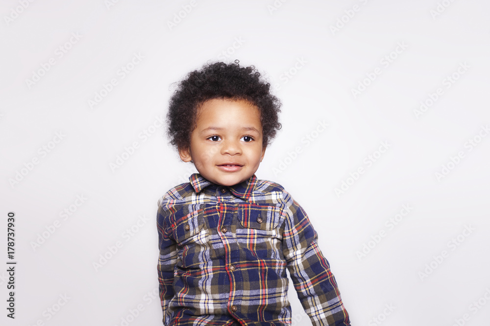 Portrait of a cute smiling african american little boy in checkered shirt isolated on white background. Portrait of a cute smiling african american little boy in checkered shirt isolated on white background.