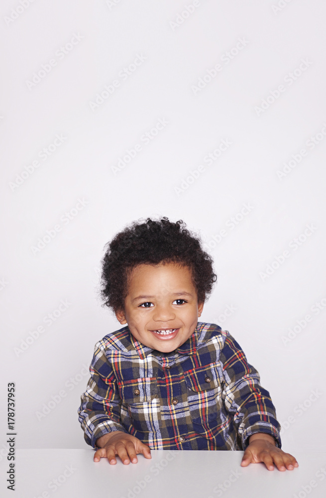 Portrait of a cute smiling african american little boy in checkered shirt isolated on white background. Portrait of a cute smiling african american little boy in checkered shirt isolated on white background.