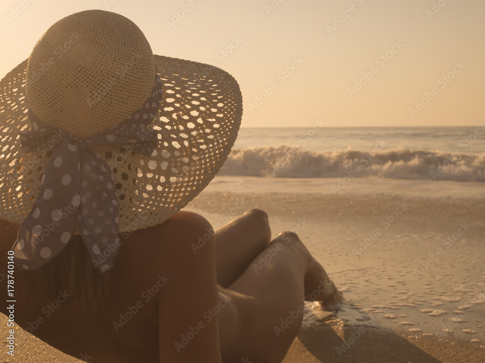 Nude Young fashion woman relax on the beach sunbathing wearing only a hat aljndr Foto Poster Wandbilder bei EuroPosters
