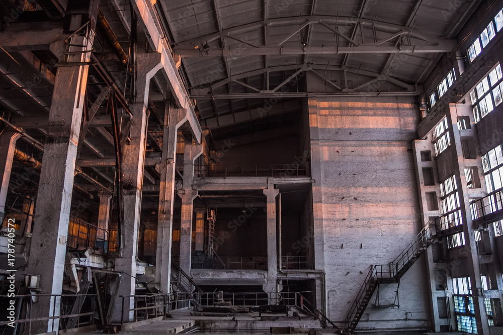 Dark industrial interior of large empty hall for manufacturing or warehousing. Abandoned factory