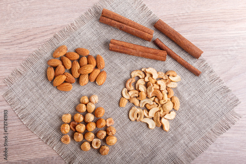  cinnamon, almonds, hazelnuts, cashew on a linen napkin.