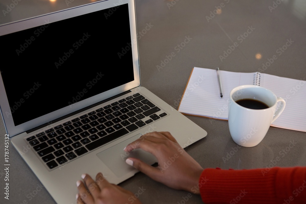 Cropped hands of woman using laptop at kitchen counter Cropped hands of woman using laptop at kitchen counter