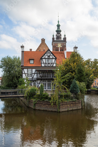 Miller's House (Dom Mlynarza) at the Mill Island on Raduni Canal in Gdansk's Old Town in Poland. It's the old headquarters of the Millers guild. St. Cathrine's Church is in the background.