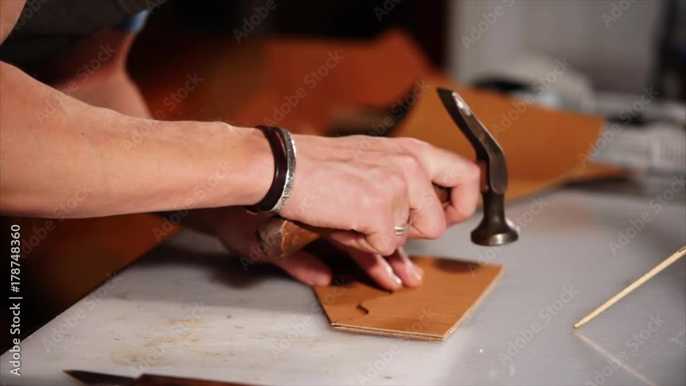 close up shot of the master hands, who makes the skin softer and smoother, the person hammers the finished parts, he is in the factory close up shot of the master hands, who makes the skin softer and smoother, the person hammers the finished parts, he is in the factory