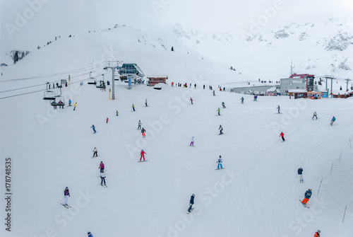 Skiers and snowboarders going down slopes of Whistler Blackcomb from above
