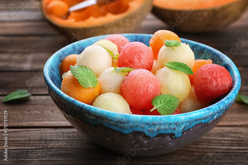 Plate with fresh melon and watermelon balls on table