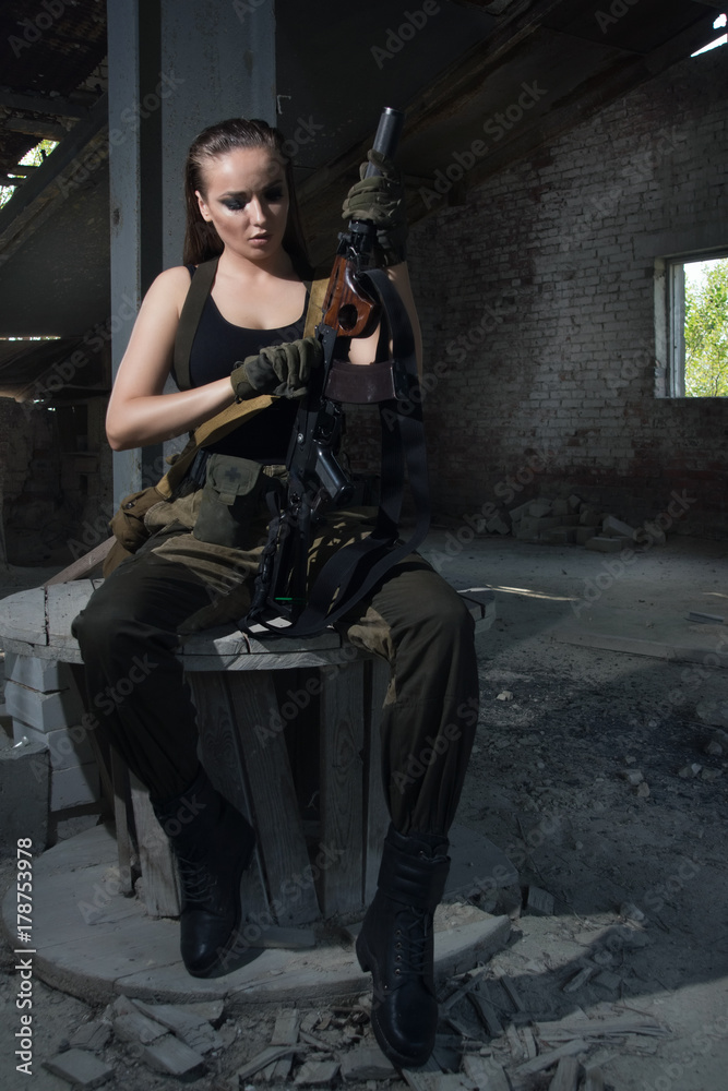 Girl with a gun in an abandoned factory