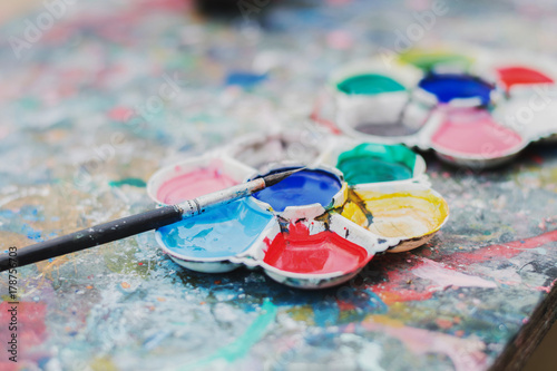 watercolor paint tray and brush on wood background