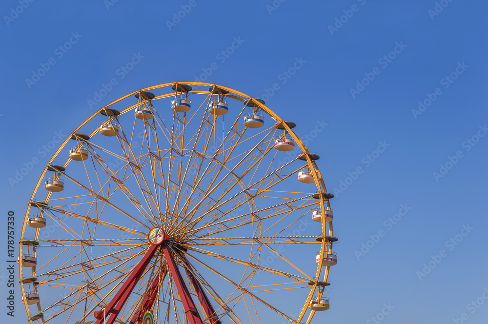 Fototapeta premium Big adventure speed circle high rollercoaster in the park with clean blue sky