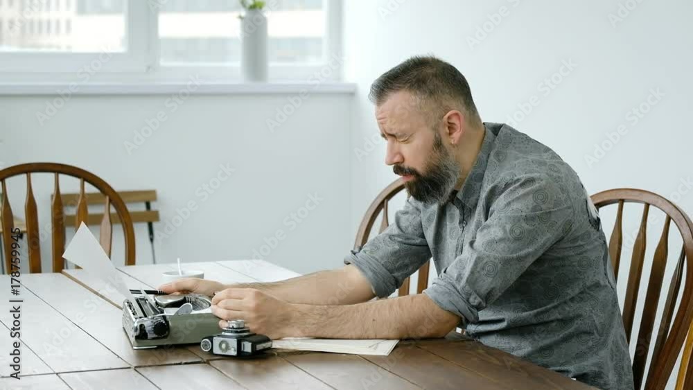 Male writer looking for inspiration and typiing on the typewriter Male writer looking for inspiration and typiing on the typewriter