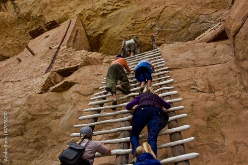 Climbing Anasazi Ruins - a group of tourists climbs a ladder to an upper floor of Anasazi cliff dwellings in Mesa Verde National Park, Colorado, U.S,A.