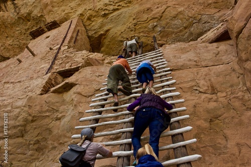 Climbing Anasazi Ruins - a group of tourists climbs a ladder to an upper floor of Anasazi cliff dwellings in Mesa Verde National Park, Colorado, U.S,A. photo