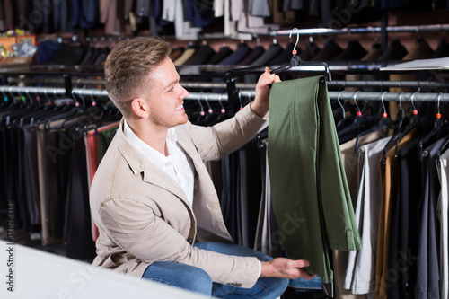 Schilderij op canvas Ordinary man choosing new trousers