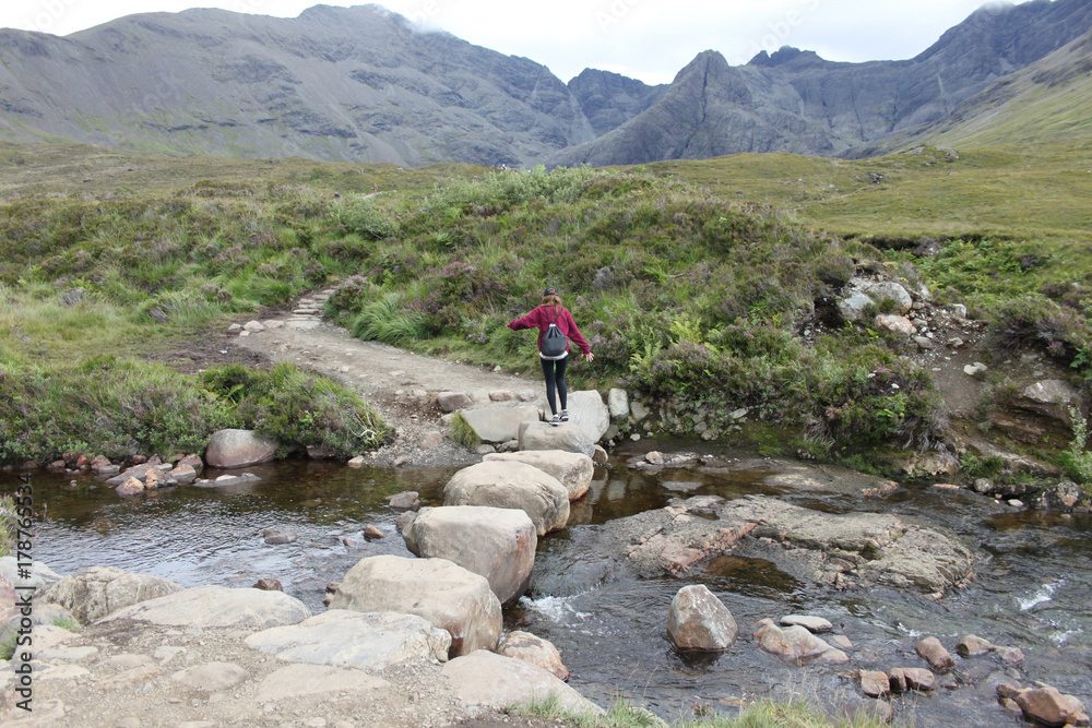 Girl crossing the rock bridge