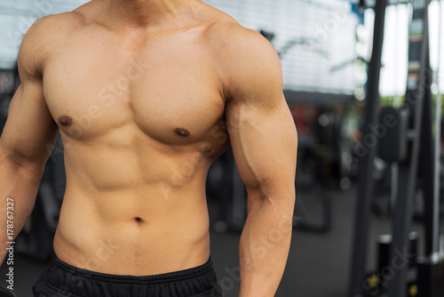 Fitness man showing muscular body in gym