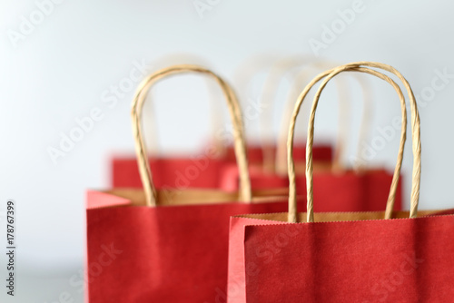 Red shopping bags from recycle paper isolated on white background. Black friday or Christmas sales.