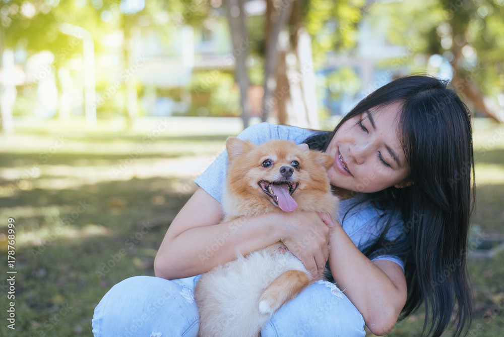 Cheerful woman playing with her dog at public park