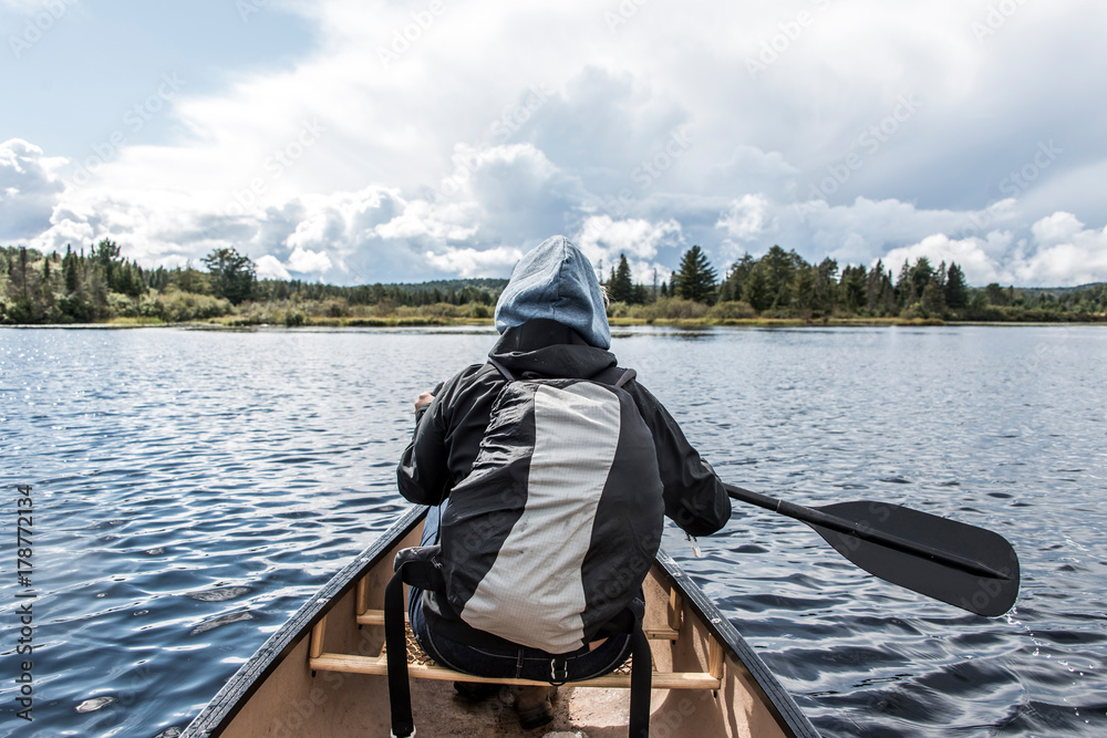 Girl canoeing with Canoe on the lake of two rivers in the algonquin national park in Ontario Canada on sunny cloudy day Girl canoeing with Canoe on the lake of two rivers in the algonquin national park in Ontario Canada on sunny cloudy day