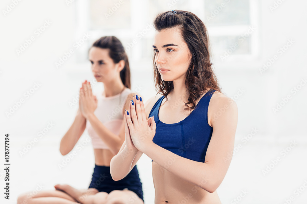 Studio shot of a young women doing yoga exercises on white background