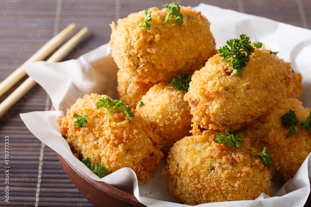 Japanese spicy potato korokke in breadcrumbs closeup in a bowl. horizontal Japanese spicy potato korokke in breadcrumbs closeup in a bowl. horizontal