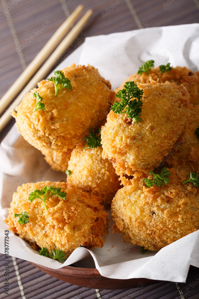 Potato croquettes, or Japanese Korokke, cooked from mashed potatoes close-up in a bowl. Vertical Potato croquettes, or Japanese Korokke, cooked from mashed potatoes close-up in a bowl. Vertical
