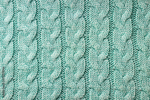 Turquoise knitted background. Knitted texture. A sample of knitting. Knitting Pattern.