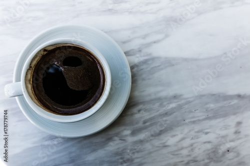 selective focus of hot coffee cup on white marble table.top view with copy space. photo